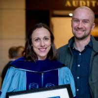 Woman poses with her certificate and guest